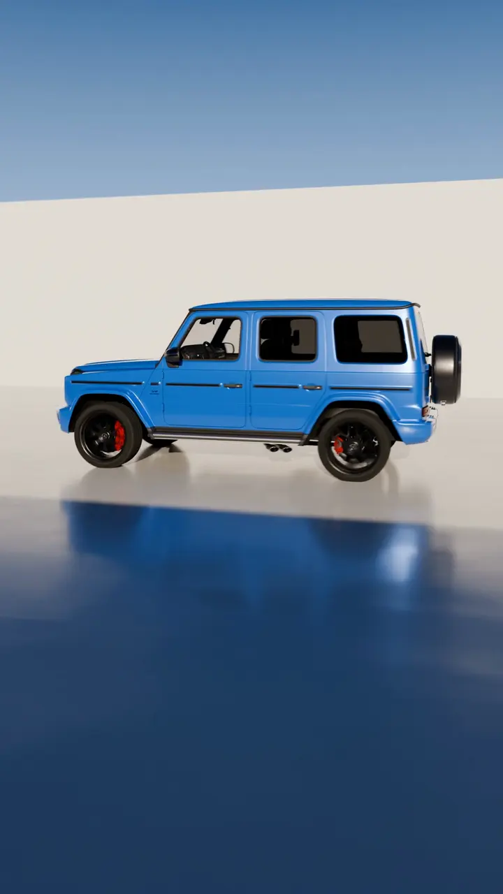 Side profile of a blue Mercedes-AMG G 63 driving across a studio floor.